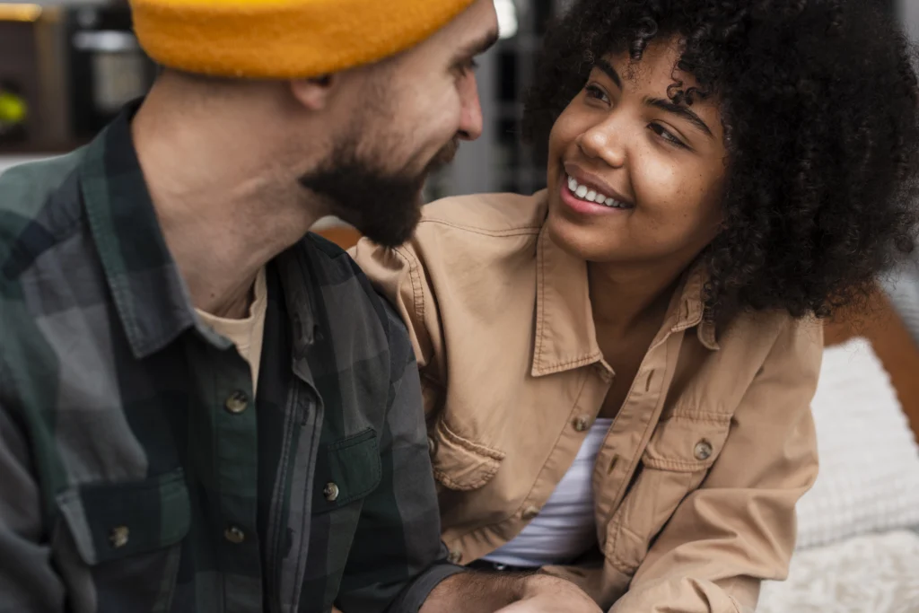 Casal de jovens olhando um para o outro e sorrindo.