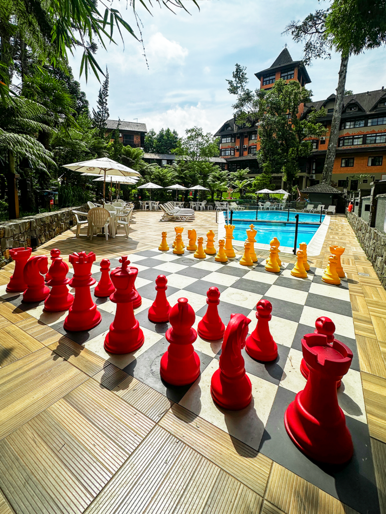 Jogo de xadrez em tamanho real com peças coloridas, durante o momento de recreação no Hotel Recanto da Serra no carnaval em Gramado.
