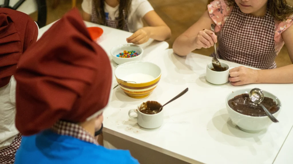 Crianças participam de uma oficina de culinária na recreação especial da Páscoa em Gramado no Hotel Recanto da Serra, preparando deliciosas receitas em um ambiente divertido e acolhedor.